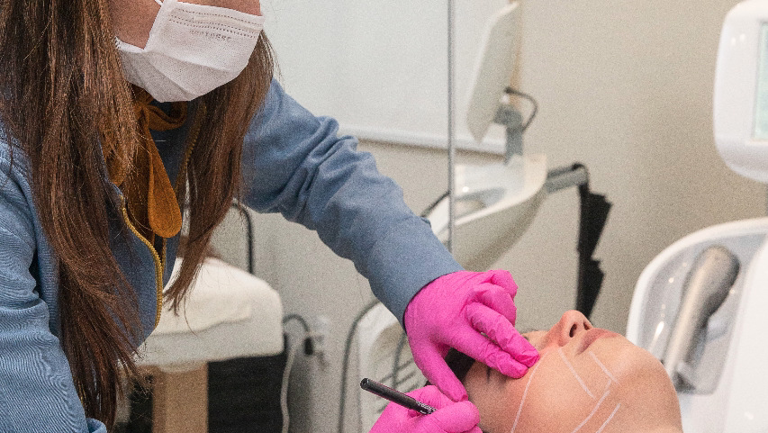 Profissional da Ono Clínica preparando aplicação de procedimento estético, ambiente real do consultório
